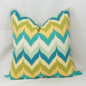 May include: A decorative pillow with a chevron pattern in shades of yellow, green, blue, and white.