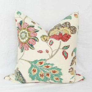 May include: A cream-colored pillow with a floral pattern in shades of red, green, and brown. The flowers are stylized and have a vintage feel.