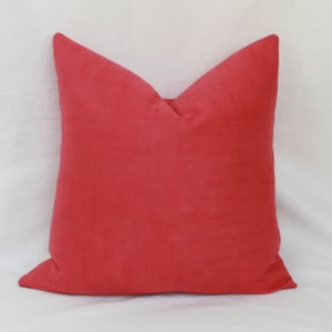 May include: A bright red square pillow with a soft, plush texture. The pillow is made of a high-quality fabric and is perfect for adding a pop of color to any room.