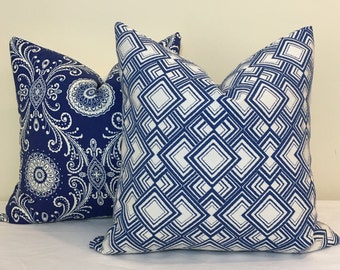 May include: Two decorative throw pillows with a blue and white geometric pattern. The pillow on the left has a paisley design, while the pillow on the right has a repeating square pattern.