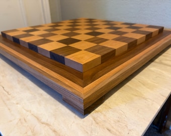 Tablero de ajedrez de nogal y cerezo con borde de maderas variadas.