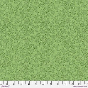 May include: A green fabric with a repeating pattern of oval shapes filled with small black dots. The ovals are arranged in a diagonal grid across the fabric. The fabric has a ruler along the bottom edge.