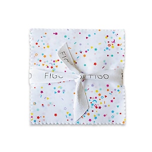May include: A square fabric bundle with a white ribbon tied around it. The fabric is white with a confetti pattern of colorful dots, stars, and crescent moons. The ribbon has the word "FIGO" printed on it.