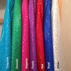 May include: Seven rolls of sequin fabric in different colors: turquoise, emerald, magenta, purple, red, royal blue, and silver.