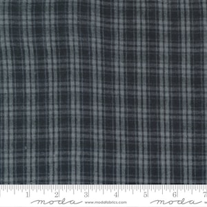 May include: A close-up of a dark gray and light gray plaid fabric. The fabric has a subtle texture and a slightly faded look. The fabric is measured in inches on a ruler.