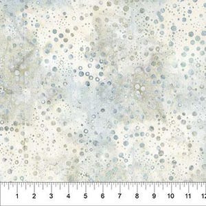 May include: A piece of fabric featuring a white background with a scattered pattern of small, muted blue and grey circles. A ruler is visible at the bottom edge, showing measurements in inches from 1 to 12, indicating the scale of the textile design.