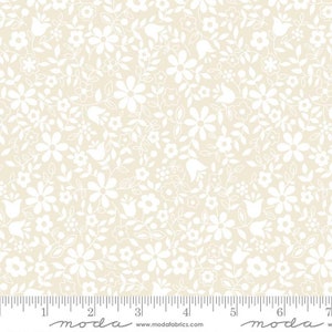 May include: Cream-colored fabric with a repeating pattern of white floral and leaf designs. The pattern includes various flower shapes and delicate foliage, creating a dense, all-over design. The fabric is suitable for quilting and other craft projects.
