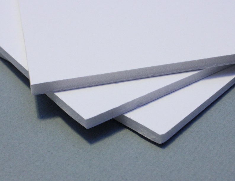 May include: Three white foam boards stacked on top of each other. The boards are smooth and have a slightly textured surface.