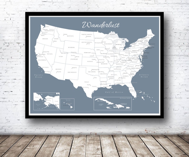Puede incluir: Un mapa de los Estados Unidos en azul y blanco con la palabra "Wanderlust" en la parte superior. El mapa incluye los estados, las principales ciudades y las masas de agua. El mapa est&aacute; enmarcado en un marco negro.