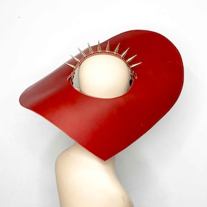 May include: A red leather hat with a wide brim and a gold spiked crown.