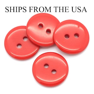 May include: Four bright red plastic buttons with two holes each. The buttons are round and have a glossy finish.