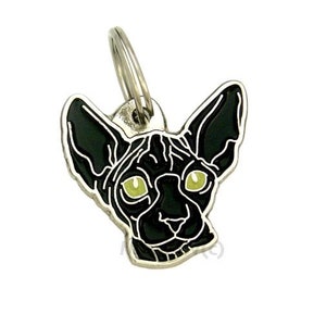 May include: A silver metal keychain featuring a black Sphynx cat with green eyes. The cat's head is facing forward with its ears perked up.
