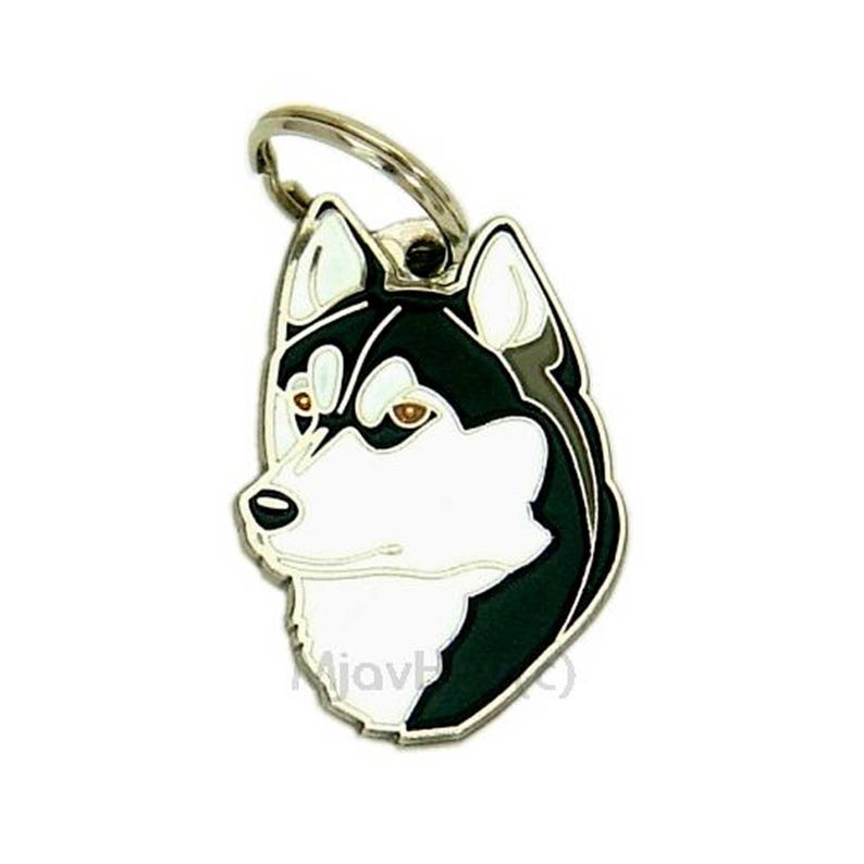 May include: A metal pet tag featuring a detailed illustration of a Husky dog's head. The tag has a silver-colored ring for attachment. The dog's face is black and white with brown eyes, and a black outline.