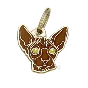 May include: A brown Sphynx cat head charm with yellow eyes, attached to a silver key ring. The charm is made of metal and has a detailed design.