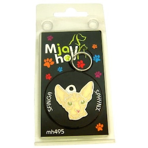 May include: A black and white round pet ID tag with a Sphynx cat image and the text "SFINGA SPHYNX" on the tag. The tag is on a black background with the text "Mjaw how mh495" on the bottom.