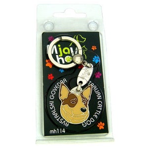 May include: A keychain featuring an Australian Cattle Dog design. The black background has colorful paw prints and a circular pendant with the dog's face. The keychain includes a silver key ring and a tag that reads "Ajay Home".