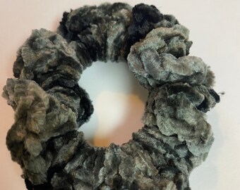 May include: A circular hair scrunchie made of soft, plush velvet fabric. The accessory features a variegated pattern of deep black, charcoal grey, and light silver-grey tones, creating a textured, multi-dimensional appearance throughout the material.