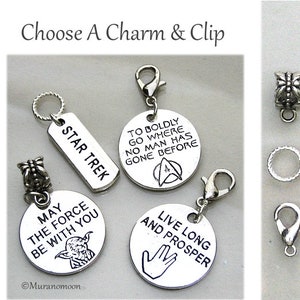 May include: Five silver charms with different designs and text. The charms include a Star Trek charm, a May the Force Be With You charm, a To Boldly Go Where No Man Has Gone Before charm, a Live Long and Prosper charm, and a charm with a Star Trek logo. The charms are for use with a bracelet or necklace.