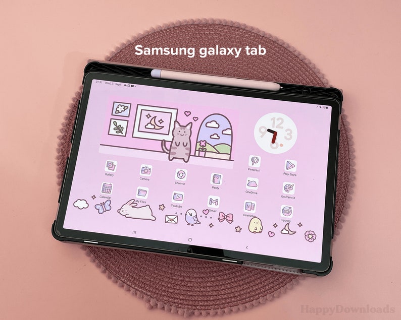 May include: A Samsung Galaxy Tab tablet with a pink and white background. The tablet has a clock widget with the time 9:73. The tablet is surrounded by a pink and white patterned case.