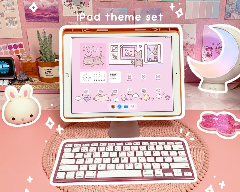 May include: A pink and white iPad theme set with a pink keyboard, a pink and white iPad case, and a pink and white moon lamp. The iPad screen shows a pink and white theme with a cat illustration and the text "Life is so sweet".