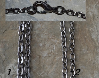 May include: Two silver chains with a lobster clasp closure. The chain on the left is a curb chain and the chain on the right is a cable chain.