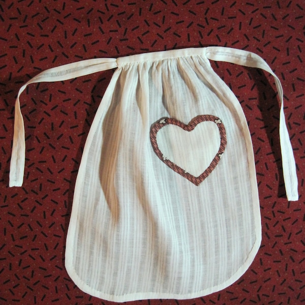 Hand sewn doll apron of antique white dimity with heart-shaped pocket trimmed in antique brown calico 8 inches long
