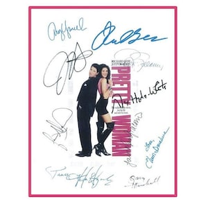 May include: A framed movie poster for "Pretty Woman" featuring Richard Gere and Julia Roberts, surrounded by signatures. The poster has a pink border and the movie title is prominently displayed.