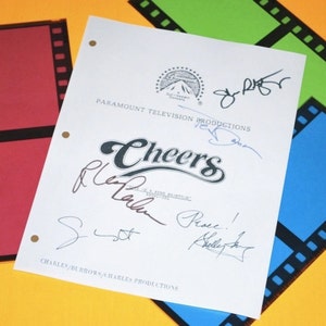 May include: A white script for the TV show "Cheers" with signatures from the cast members. The signatures include Ted Danson, Shelley Long,  and  the show's creator Glen and Les Charles.