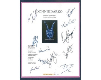May include: A white script with the title "Donnie Darko" and the release date "October 20, 2001". The script is signed by the cast and crew, including Jena Malone, Katherine Ross, and the director Richard Kelly.