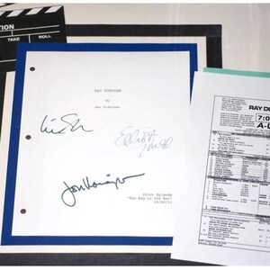 May include: A white sheet of paper with the title "Ray Donovan" and the text "Pilot Episode - The Bay on the Bat 05/26/11". The paper is signed by three people, including Liev Schreiber, who is known for his role in the show.