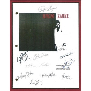May include: A white framed poster with a black and white image of Al Pacino as Tony Montana from the movie Scarface. The poster is signed by Al Pacino, Oliver Stone, Steven Bauer, Michelle Pfeiffer, Mary Elizabeth Mastrantonio, Robert Loggia, and F. Murray Abraham. The poster also includes the text "AL PACINO SCARFACE ORIGINAL Release One Universal Studios".