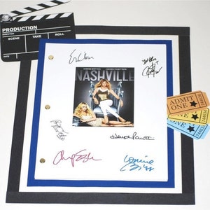 May include: A white sheet of paper with multiple signatures in black ink. The signatures include "Ercion", "Risotto", "Chip Eskin", "Connie Britton", "LeAnn Rimes", and "Keith Urban". The paper is framed with a black and blue border. A movie clapperboard and three yellow and blue tickets are visible in the background.