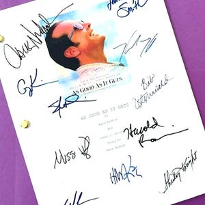 May include: A white movie script page with multiple signatures in black ink. The page features a movie poster image and the title "AS GOOD AS IT GETS". The script is held together with gold brads, set against a purple background.