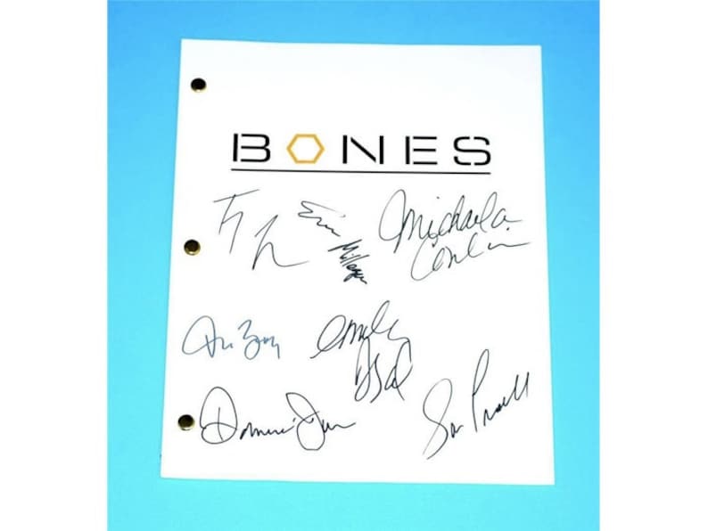 Może przedstawiać: Biała kartka papieru z nadrukowanym na g&oacute;rze czarnym napisem "BONES". Papier jest podpisany przez sześć os&oacute;b, w tym Emily Deschanel, David Boreanaz i Michaela Conlin.