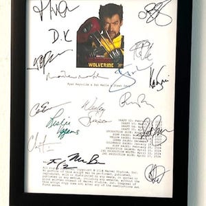 May include: A black framed print of a movie script with signatures from the cast and crew of the movie Wolverine. The script is titled "Wolverine" and includes the names of the actors, directors, and producers. The signatures are in black ink and are legible. The print is in good condition and is ready to be framed.