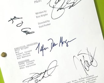 May include: A white script page for the television show "Supernatural" with multiple signatures in black ink. The script title "Pilot" is visible, along with the names of the writer, director, and executive producers.