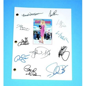 May include: A white script with multiple signatures from the cast of the movie Legally Blonde. The signatures include Reese Witherspoon, Jennifer Coolidge, Selma Blair, and more. The movie poster for Legally Blonde is in the center of the script.