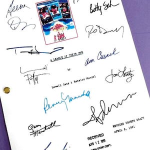 May include: A white script page with a movie poster for "A League of Their Own" and multiple signatures from the cast and crew, including Geena Davis, Tom Hanks, and Rosie O'Donnell. The page also includes the title "A League of Their Own" and the text "Revised Fourth Draft April 8, 1991".
