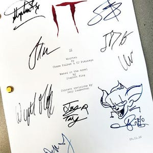May include: A signed script for the movie "IT" with the title written in red. The script is signed by the writers, director, and cast members, including Bill Skarsgård, who plays Pennywise the Dancing Clown. The script is dated 03.11.16.