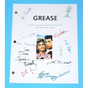May include: A signed script for the movie Grease, featuring the title card and a photo of the main actors. The script is signed by several cast members, including John Travolta, Olivia Newton-John, and Jamie Donnelly.