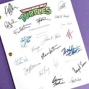 May include: A white sheet of paper with the title "Teenage Mutant Ninja Turtles" and signatures from the cast and crew of the movie. The signatures include: Kevin Eastman, Peter Laird, Todd W. Langen, Josh Pais, Jim Davis, April O'Neil, Brian Tochi, and others.