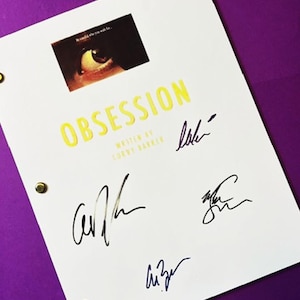 May include: A white script titled Obsession written by Curry Barker, featuring a rectangular graphic of an eye with the text Be careful who you wish for. The document includes four distinct black ink signatures and is bound with three gold metal fasteners.