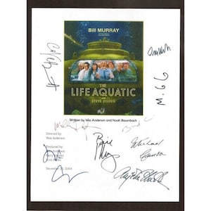 May include: A white sheet of paper with a movie poster for "The Life Aquatic with Steve Zissou" featuring Bill Murray. The poster is signed by Bill Murray, Wes Anderson, Owen Wilson, Michael Gambon, and Anjelica Huston. The text "Written by Wes Anderson and Noah Baumbach" is also visible.