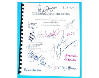 May include: A black and white script for the musical "The Phantom of the Opera" with signatures from the cast and crew. The signatures include names like "Joel Schumacher", "Andrew Lloyd Webber", "Jon Shuancher", and "Miranda Richardson".