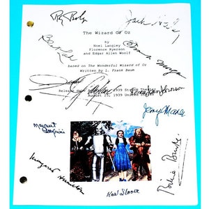 May include: A black and white photo of the cast of the 1939 film "The Wizard of Oz" with their autographs. The photo shows Dorothy, the Tin Man, the Scarecrow, and the Cowardly Lion. The signatures include Judy Garland, Ray Bolger, Jack Haley, and Bert Lahr.