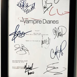 May include: A framed script for the pilot episode of the TV show "The Vampire Diaries". The script is signed by the cast and crew, including Kevin Williamson, Julie Plec, and Michael Trevino. The script is dated February 4, 2009.