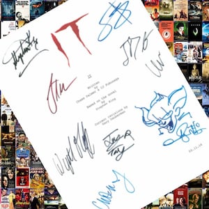 May include: A white sheet of paper with blue and red signatures. The signatures are from the cast and crew of the movie "IT". The text on the paper reads "Written by Chase Palmer & Cary Pukunaga Based on the novel by Stephen King Current revisions by Gary Dauberman".