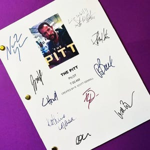 May include: A white script page for the television pilot The Pitt, featuring a central image of a man, the text The Pitt, Pilot, 7:00 AM, Created by R. Scott Gemmill, and multiple ink signatures. The document is secured with three gold metal fasteners.