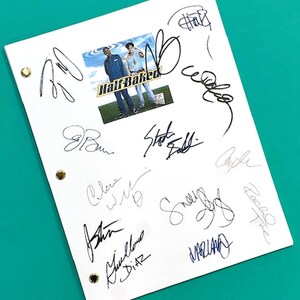 May include: A white script with multiple signatures and a Half Baked movie promotional image. The script has three gold-colored grommets along the left edge. The Half Baked image features three men.