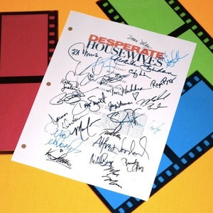 May include: A white sheet of paper with the title "Desperate Housewives" in orange and black lettering. The paper is signed by the cast of the television show, including Teri Hatcher, Felicity Huffman, Eva Longoria, and Marcia Cross.